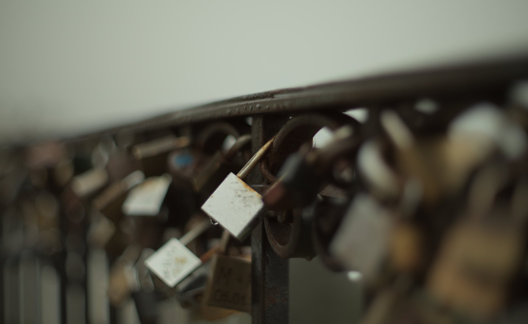 locks adorn a damp railing, cold wet and rusty, the focus band is super narrow