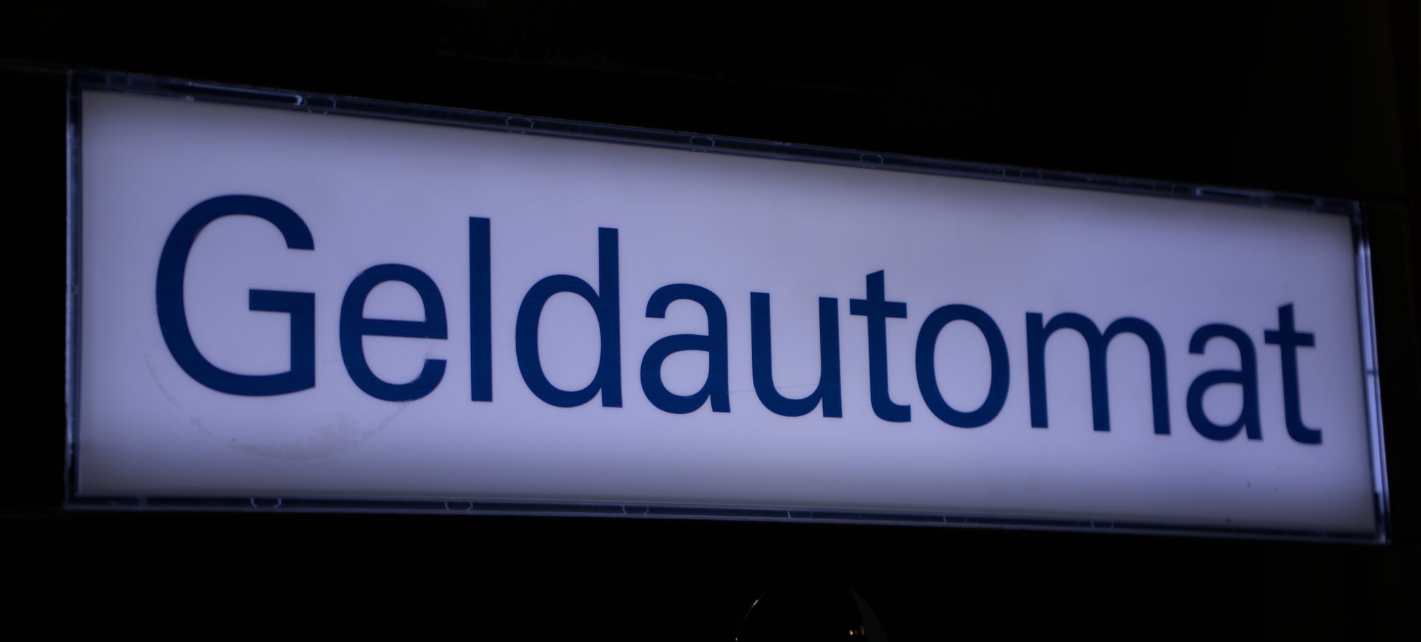 an illuminated sign that says "Geldautomat" (ATM, but in german)