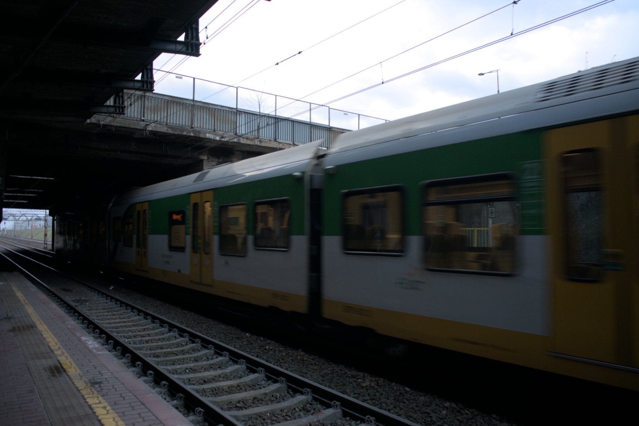 some rolling stock, nyooooming on past the viewer, with green and yellow livery