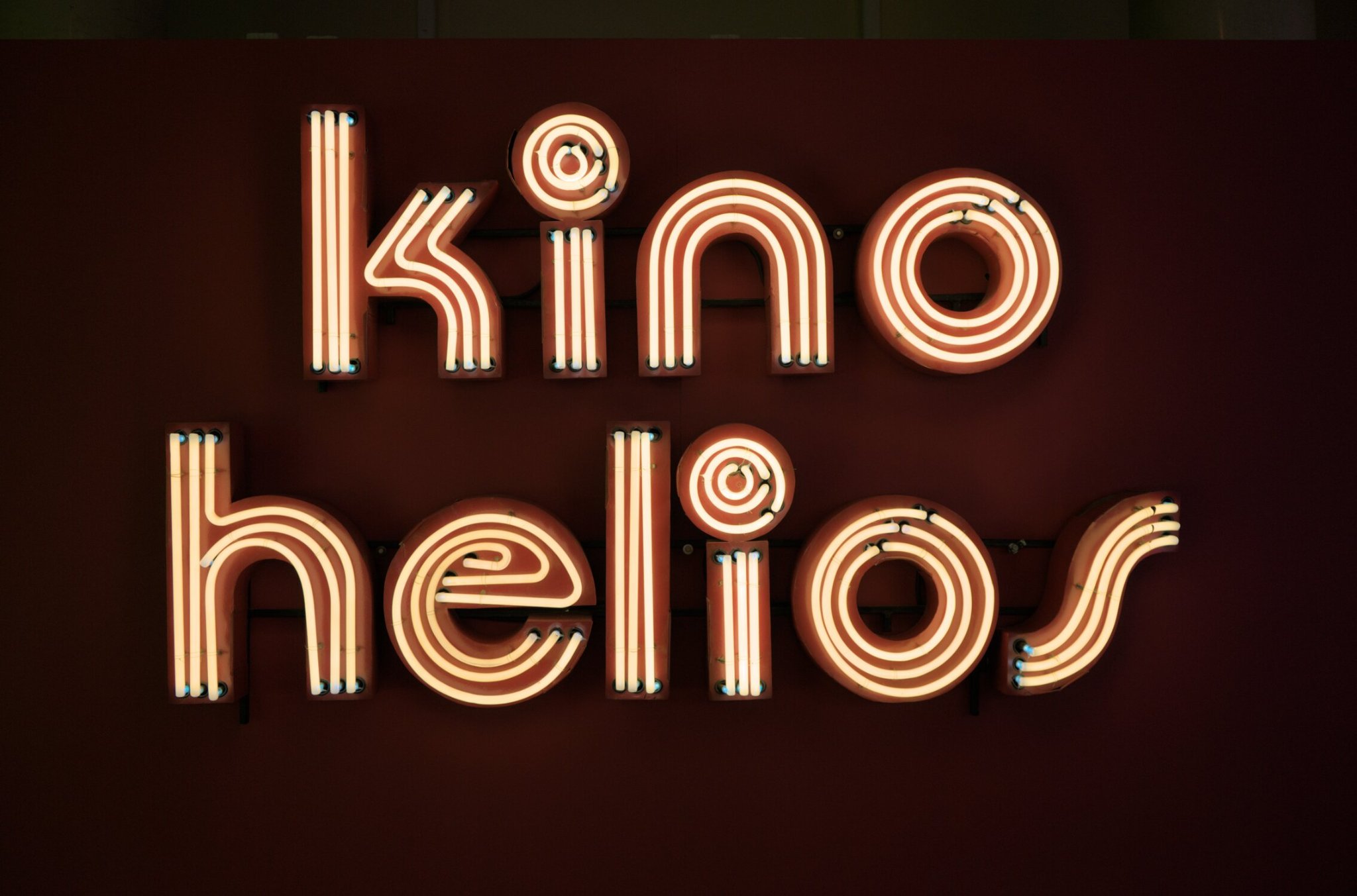 some yellow neon in the shape of the words 'kino helios'