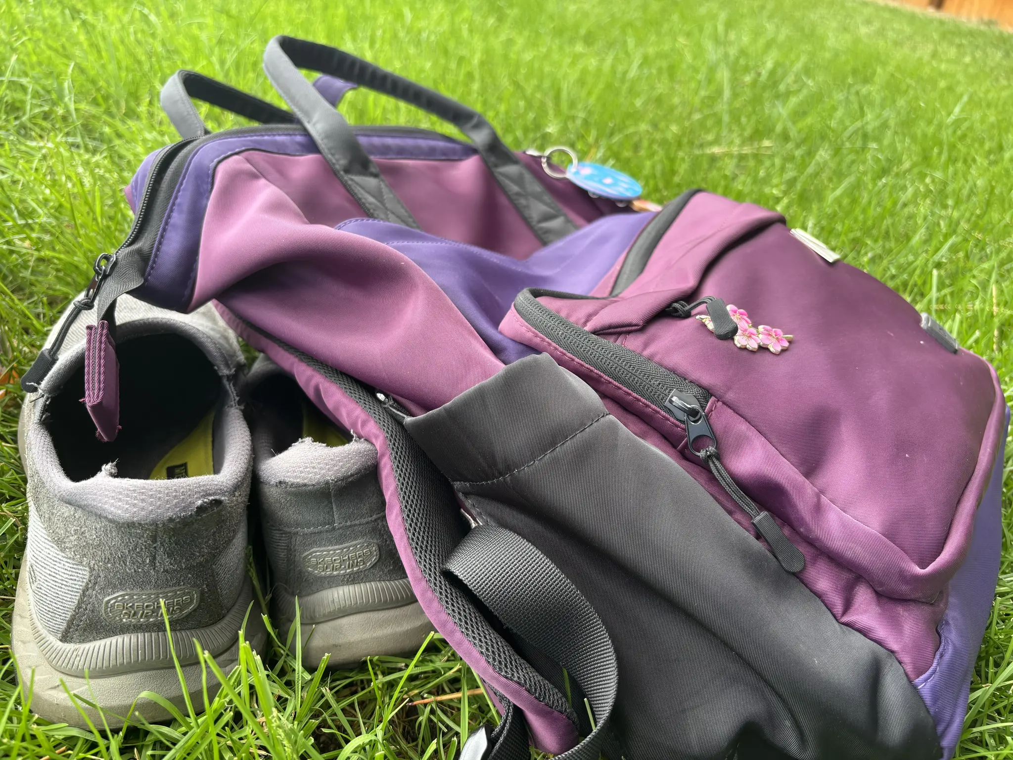 my purple backpack resting on my gray loafers in the grass