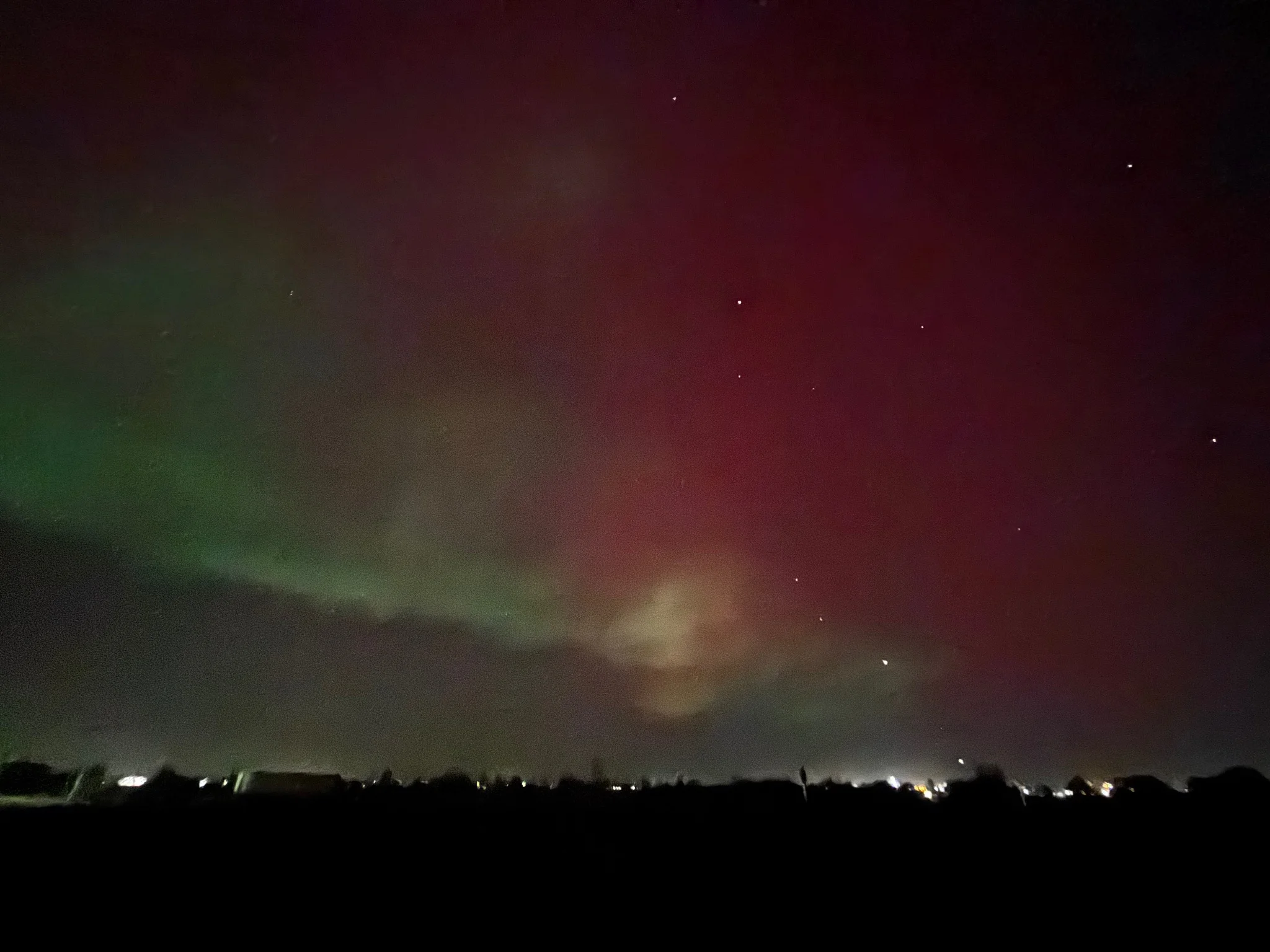 very red and green aaurora, with stars peeking through 