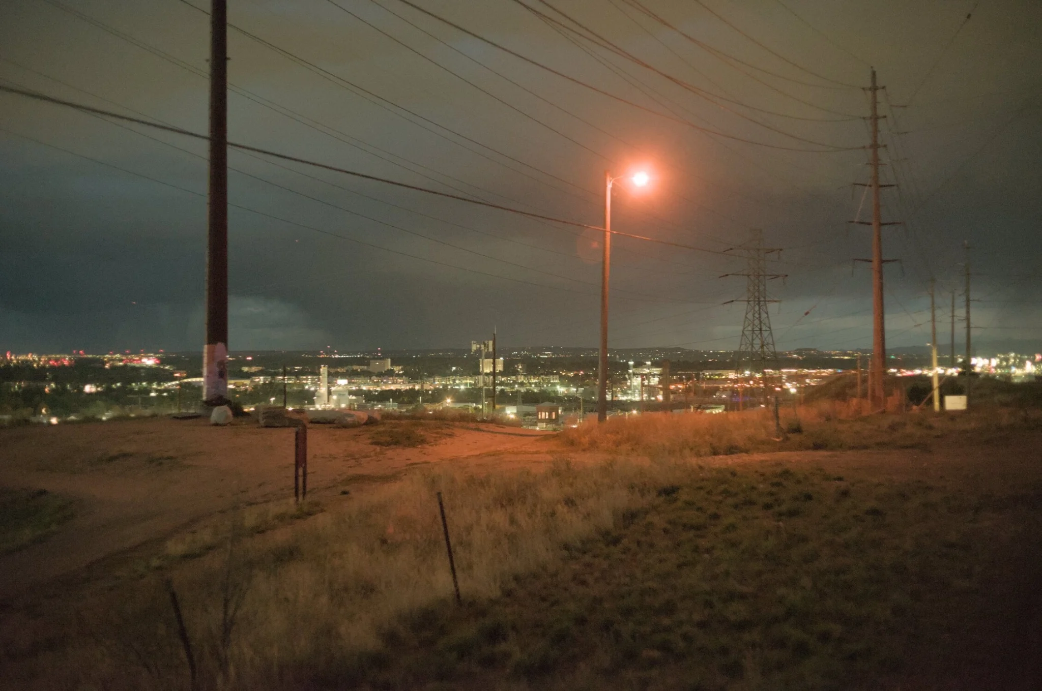 a light pole, with city lights far off in the background