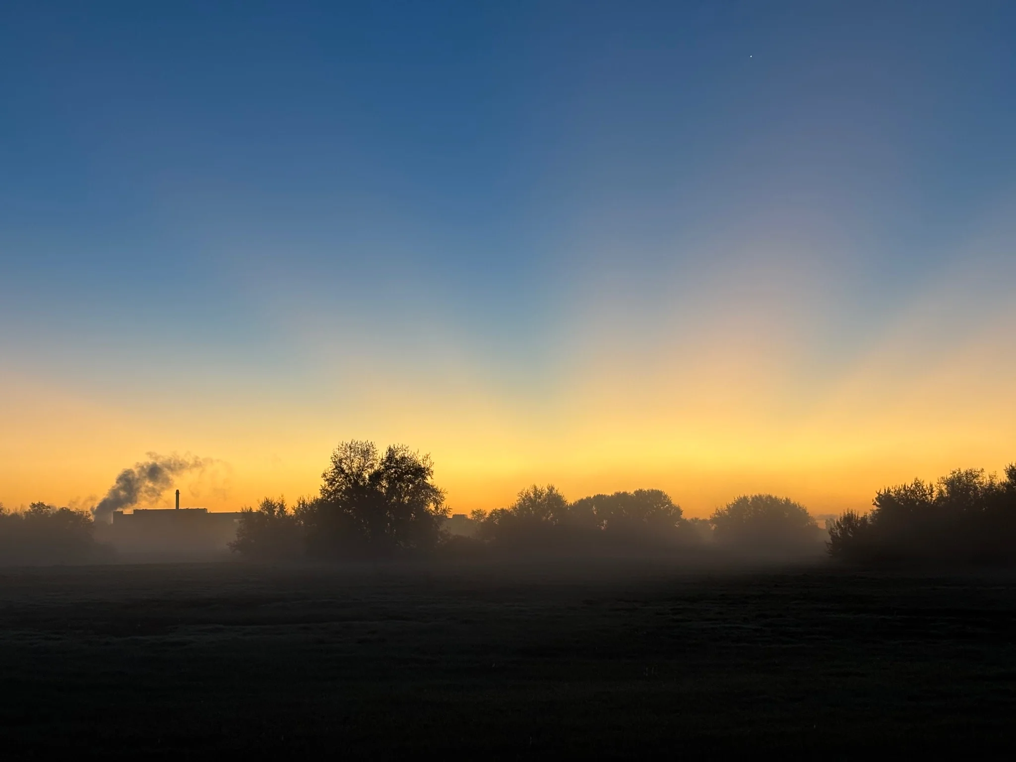 the same scene, but somewhat more zoomed in, so that the factory is a bit more visible on the horizon
the crepuscular rays are also a bit more intense in this shot