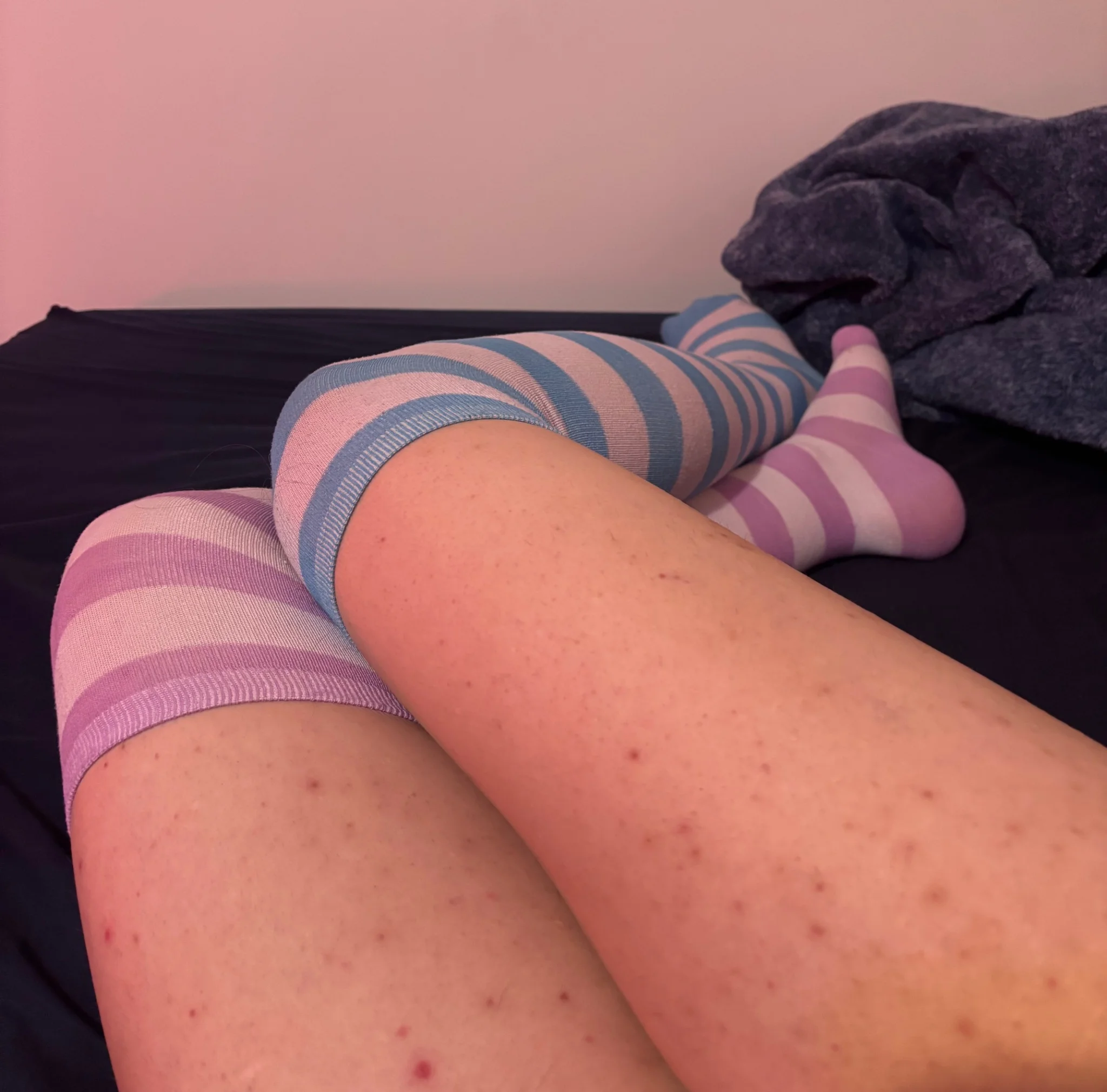 more of my legs, this time with no skirt in frame, very much thighs filling frame, with me laying so my knees are pointing off to the left, my right leg crossed over the left