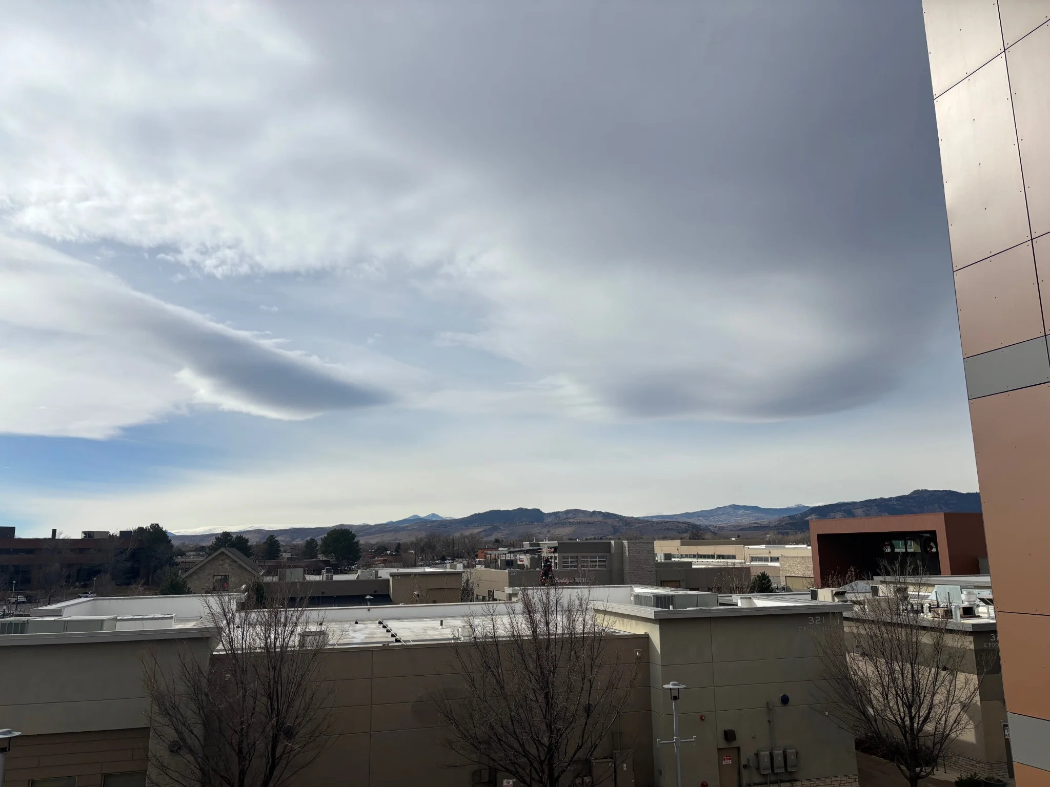 looking out from the parking garage onto the mall, mountains can be seen in the distance, the sky is cloudy