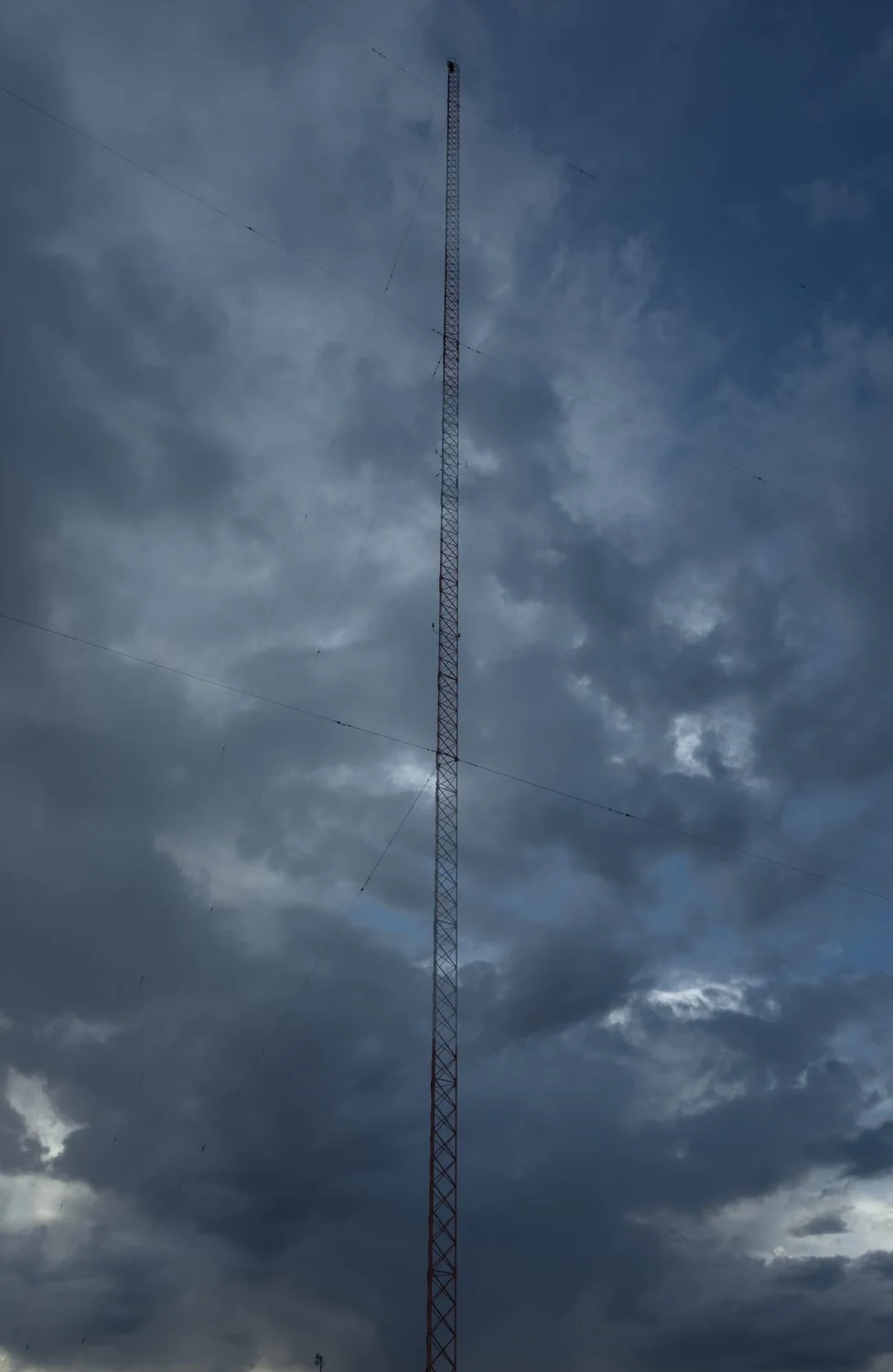 a radio communications tower, with cloudy skies behind