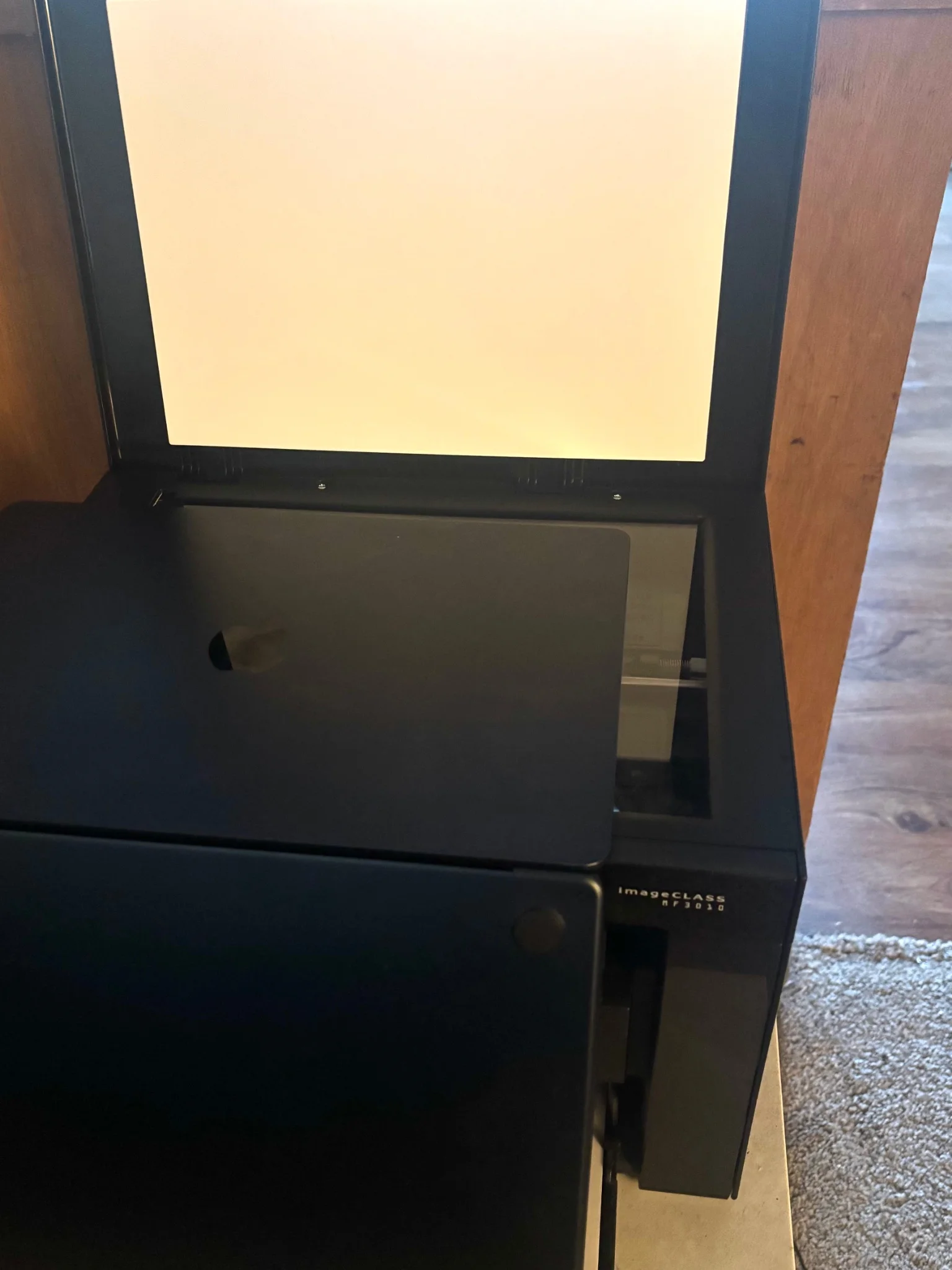a laptop, sitting screen down on a flatbed scanner