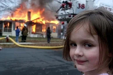 a child smugly smiling in front of a burning house
