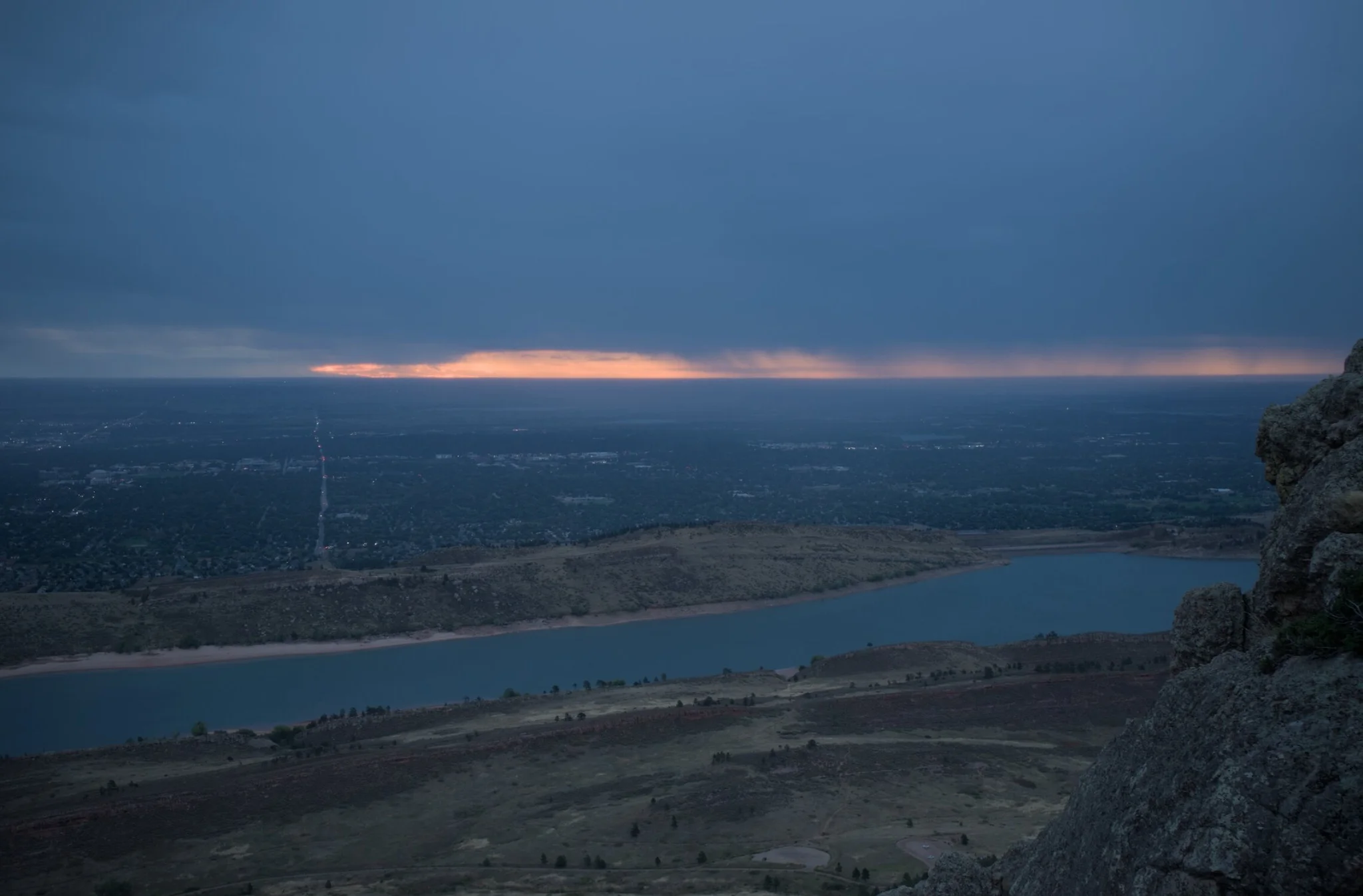 overlooking the city and reservoir , we see rain in the distance, and the sun's beautiful morning light peeking through the clouds, the world is finally awoken