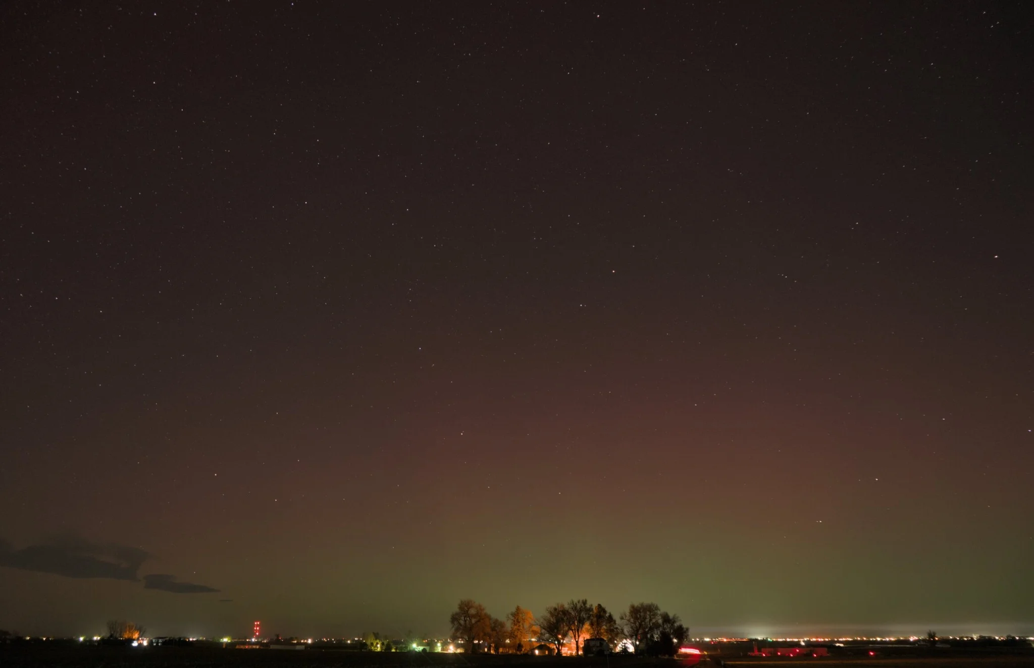 the aurora fading as the moon was rising, the horizon shining brightly with the city lights