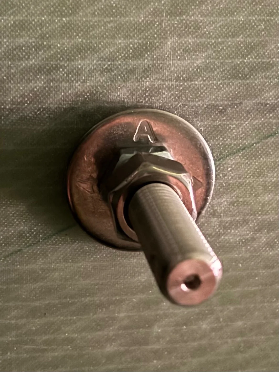 a bolt, attached with a nut and washer. on the washer is engraved 'A'