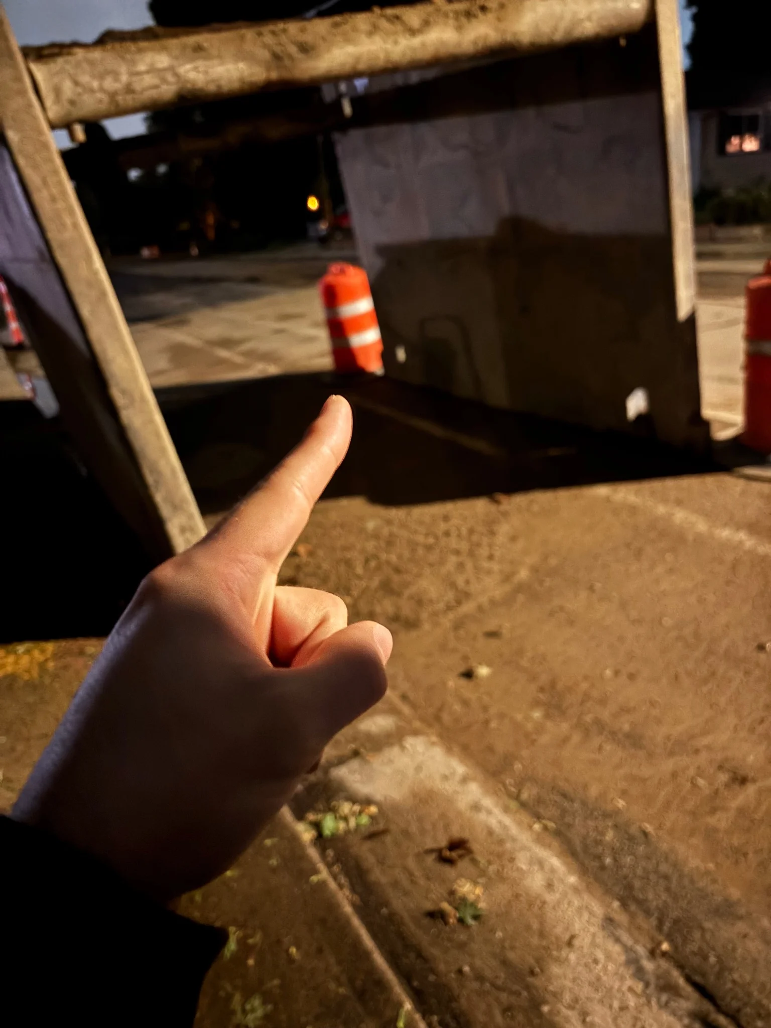 some sort of metal squareish thingy, i think it goes underground
in the foreground is my hand, pointing at a traffic cone.. barrel thing.. for some reason